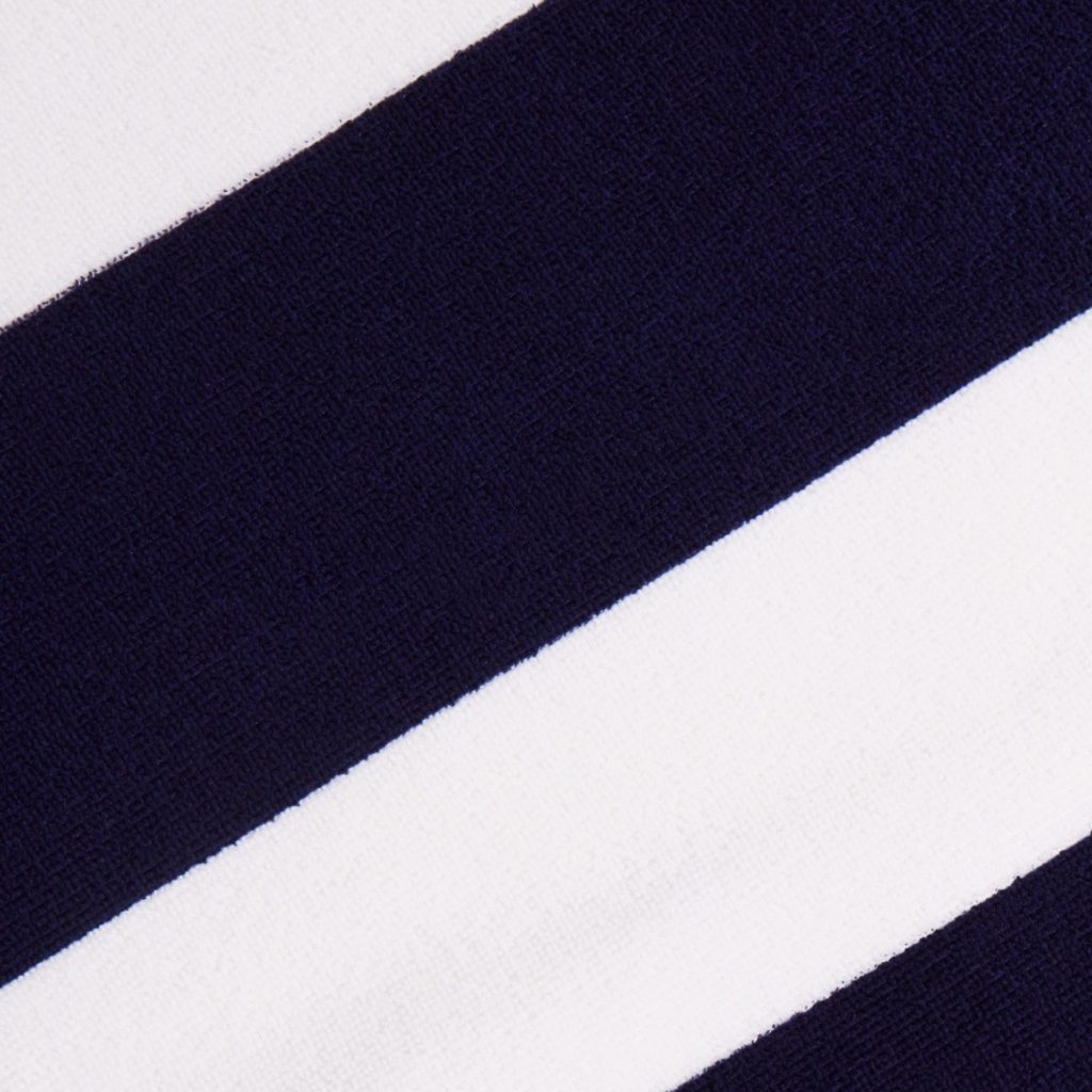 A close-up image of a blue and white fabric, possibly a beach towel, with white and black stripes. The image is taken from a top-down view, showcasing the design on the fabric.