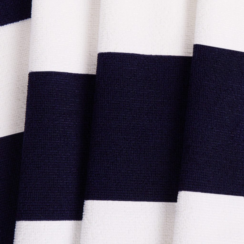 A close-up image of a white and black fabric, featuring vertical stripes, is presented. The fabric appears to be cotton, and it is being displayed in a white background.