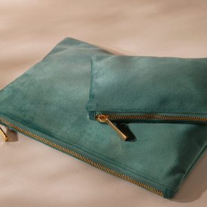 A pair of accessories in a green color is depicted in this image. The accessories are placed on a white surface, which also features a few other unidentified objects.