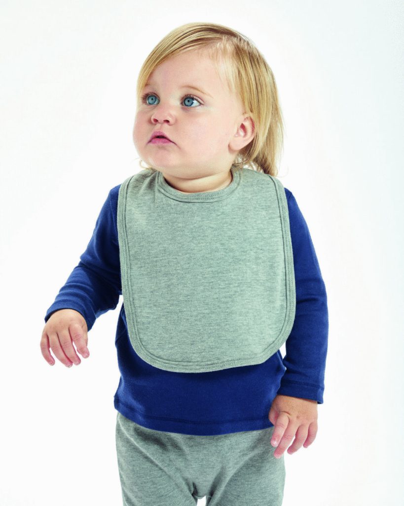 A baby is positioned in the center of the image, dressed in a blue top and grey bib. The background is white, and the image is taken from a top-down perspective.