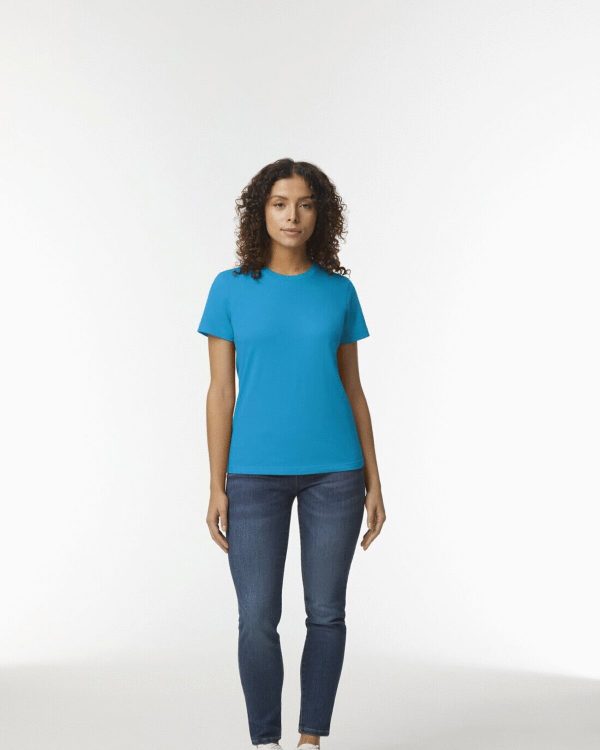 A woman is standing in the image, dressed in a blue T-shirt and blue jeans. The background is white.