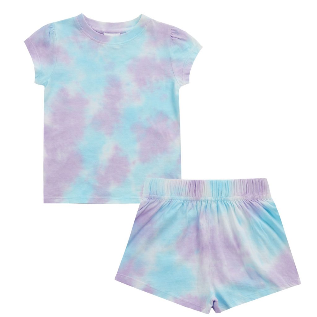 A child is depicted in this image, wearing a blue tie-dye t-shirt and violet shorts. The background is white, and the image is slightly blurry in the background.