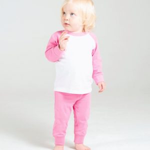 A child is standing in the image, dressed in a white and pink outfit. The background is white, and the image is taken in a studio setting.
