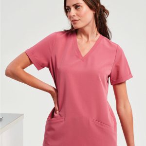 A woman is standing in the image, dressed in a pink dress and a pink top. The background is white, and the image is blurred in the background.