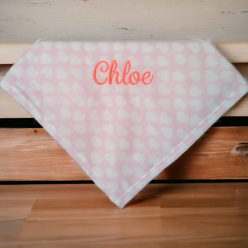 A pink fabric is depicted in this image, featuring white and pink dots. The word "chloe" is written in red letters on the fabric. The background is white.