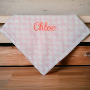 A pink fabric is depicted in this image, featuring white and pink dots. The word "CHloe" is written in red letters on the fabric. The background is white.