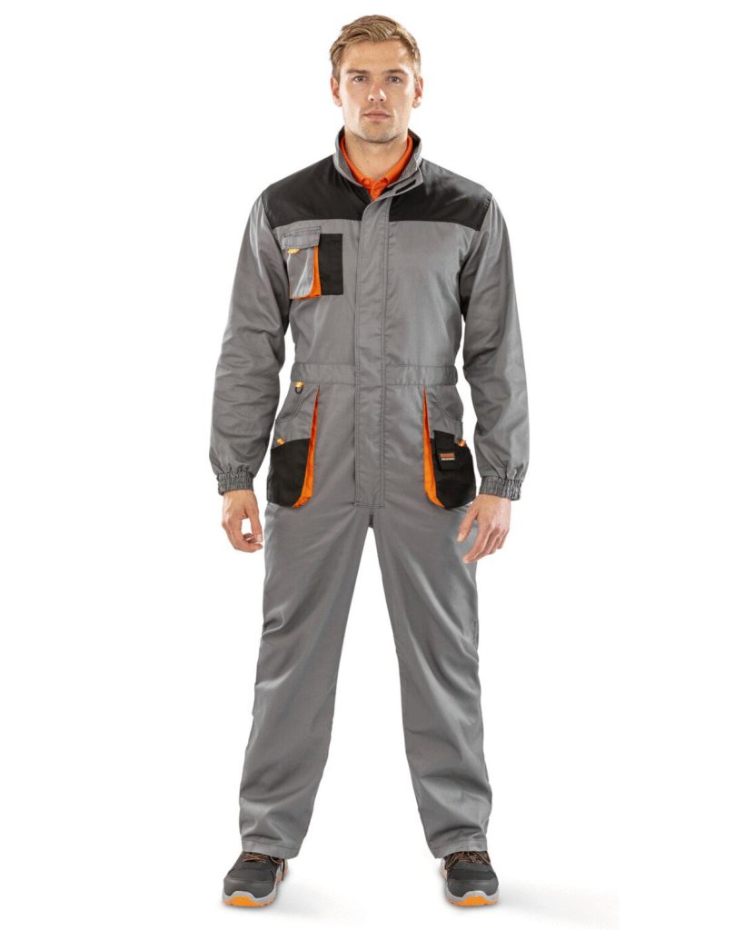 A man is standing in the image, dressed in a grey coverall with orange accents. The background is white.