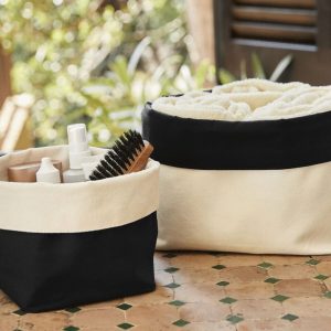 A black and white canvas holder is depicted in this image, with a cream-colored cloth placed on top. The holder contains a brush, a cream-colored cream, and a black and white cloth.