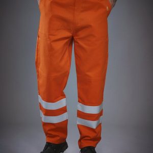 A man is standing in the image, dressed in orange pants with reflective flame retardant. The pants have a reflective strip on the inside, and the background is white.