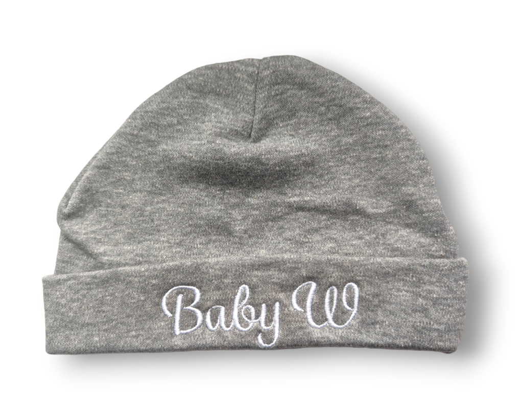 A grey beanie hat is the central focus of this image, with the word "baby w" embroidered on it. The background is white.