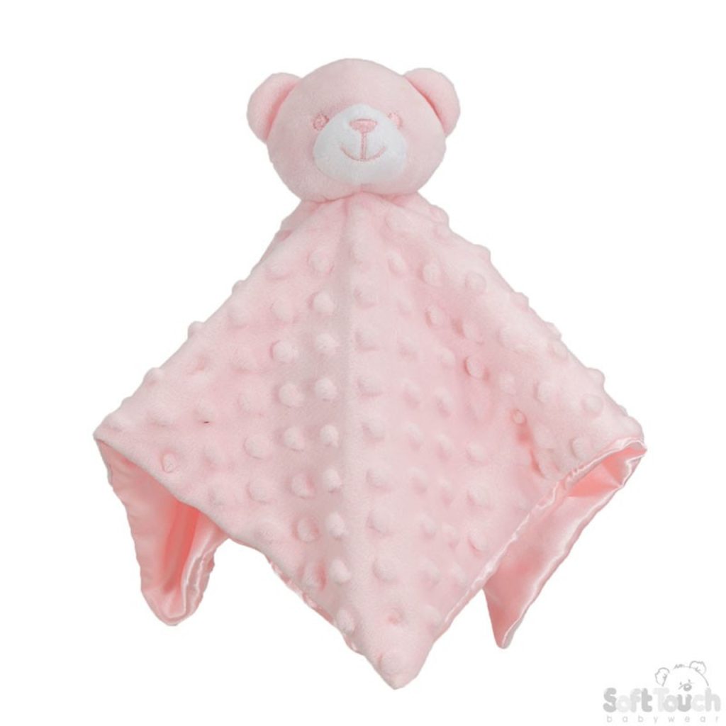 A pink bear is the central focus of this image, with a white background. The bear is adorned with white and pink fur, and it is placed on a bed with a white sheet.