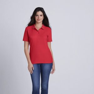 A woman is standing in the image, dressed in a red t-shirt and blue jeans. She is smiling and posing for the camera. The background is white.