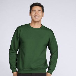 A man is standing and smiling in the image, dressed in a green sweatshirt. The background is white.