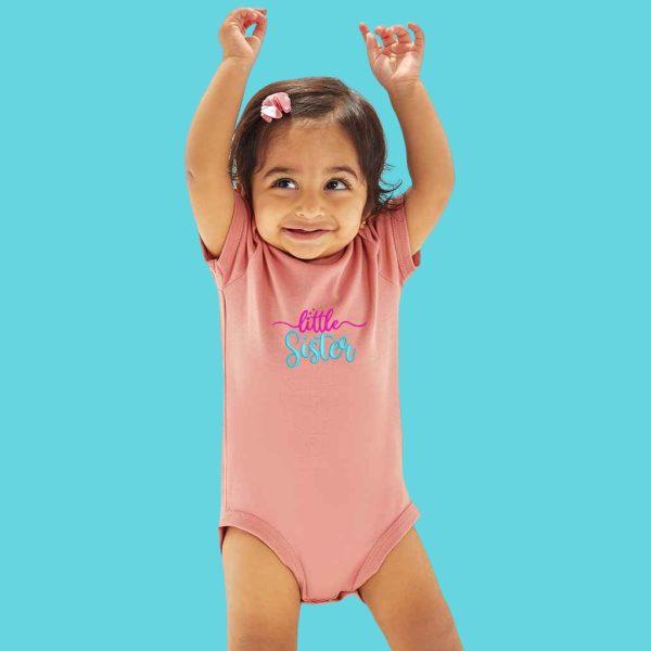 A baby is depicted in this image, wearing a pink bodysuit with the word "LITTLE SISTER" written on it. The baby is smiling and appears to be posing for the camera.