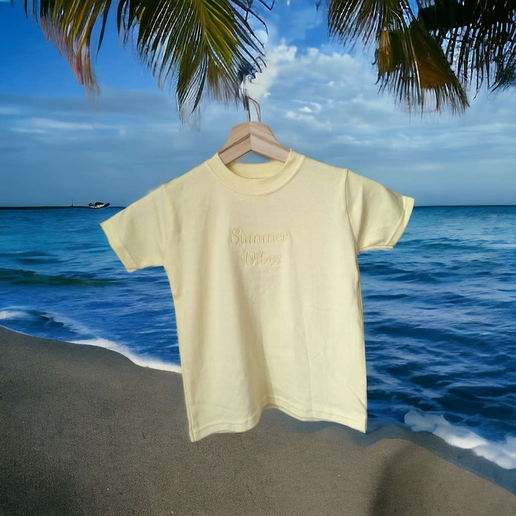 A yellow t-shirt is displayed in the image, featuring the word "lemon" written on it. The shirt is hanging on a hanger, and the background includes a beach scene with water and a boat.