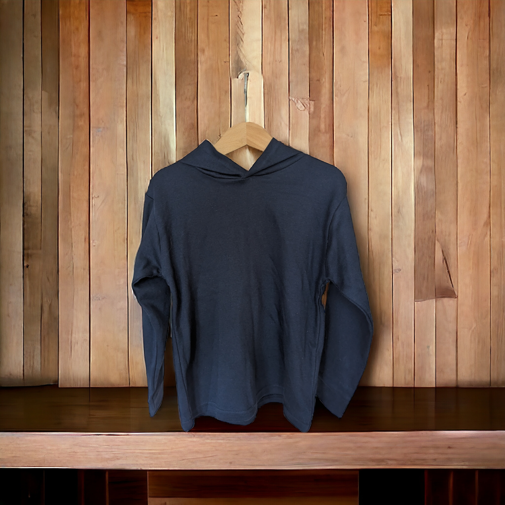 A blue hoodie is displayed on a wooden surface, with a wooden wall in the background. The hoodie is unbuttoned, and a wooden hanger is visible.