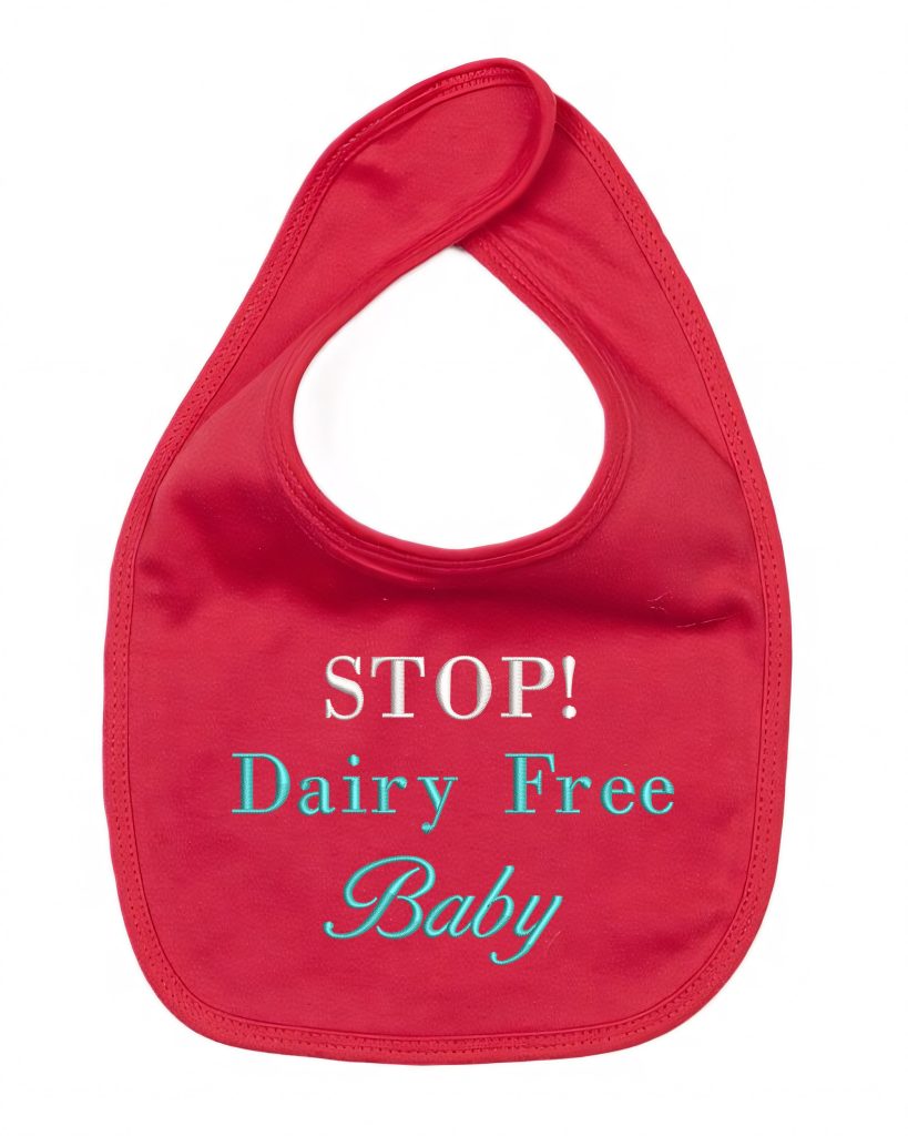 A red-colored bib is depicted in this image, featuring a logo and the text "stop dairy free baby. " the background is white.