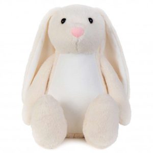 A white stuffed bunny is the central focus of this image, with a cream-colored background. The image is slightly blurry in the background, and the bunny appears to be wearing a tag.
