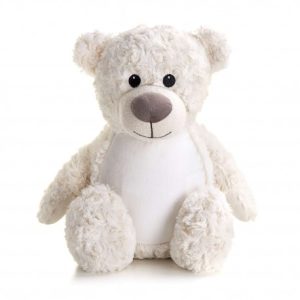 A white teddy bear is the central focus of this image, with a cream-colored background. The bear is adorned with a cream-colored tag, and a white background is visible in the top right corner.