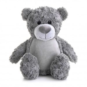 A teddy bear is the central focus of this image, with a white background. The bear is dressed in a grey and black outfit, featuring a black nose and a white face.