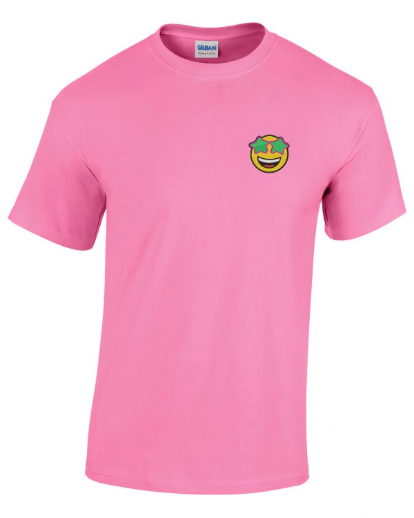 A pink T-shirt is displayed in the image, featuring a cartoon face and a green patch. The background is white.