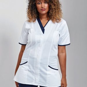 A woman is standing in the image, dressed in a white tunic with blue accents. She is wearing a black top and blue pants. The background is white.