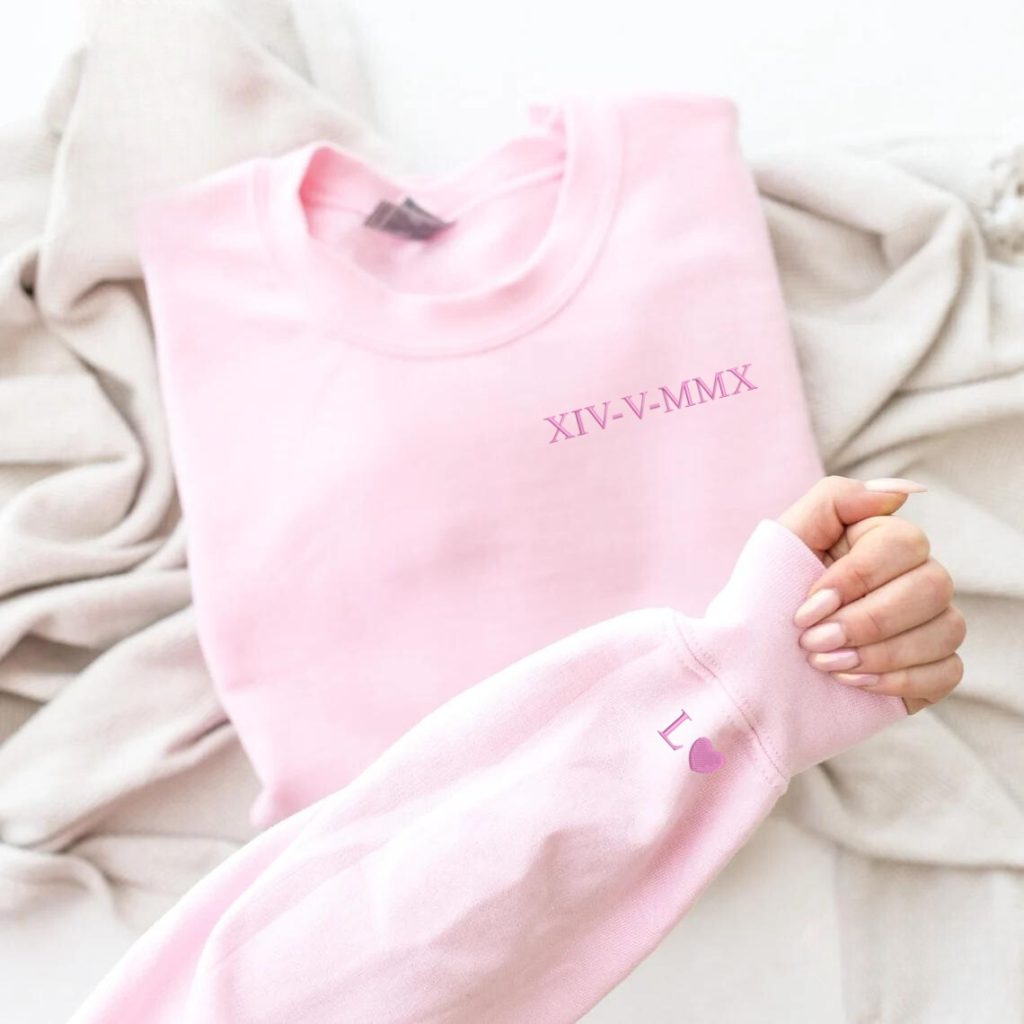 A pink sweatshirt is displayed in the image